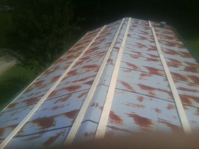 Rusted metal roof panels with new wood purlins before replacement — Storm Damage Roof Repair in Montverde by Roofing Brothers