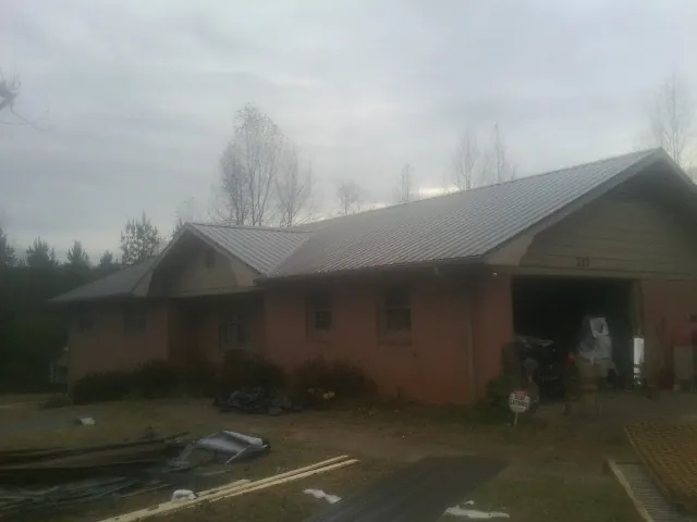 Gray metal roof on a stucco house with an attached garage in Montverde